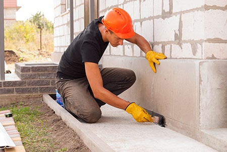 Worker Applies Bitumen Mastic on the Foundation